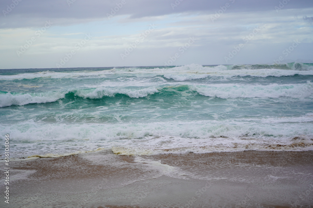Praia do Magoito, Sintra, Portugal - March 2023: View of the ocean, rocks, sand and waves on the beach. Atlantic Ocean. Praia do Magoito, Sintra, Portugal - March 2023: View of the ocean, rocks, sand and waves on the beach. Atlantic Ocean.