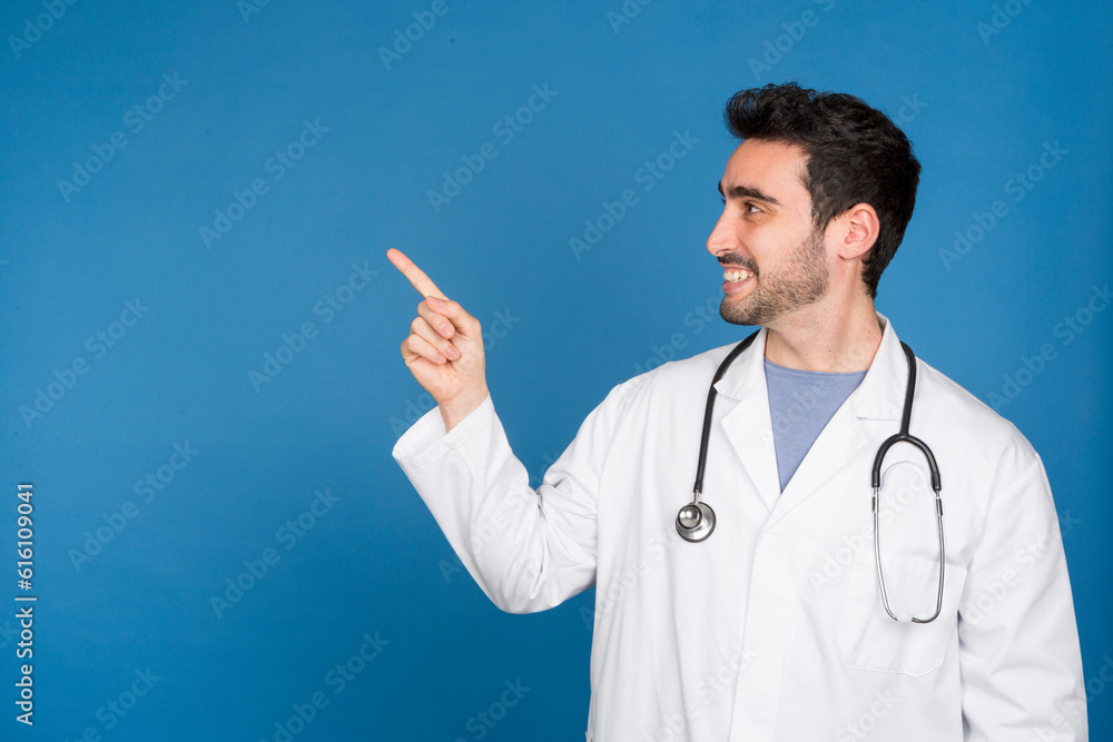 Smiling doctor pointing to copy space in studio Smiling doctor pointing to copy space in studio