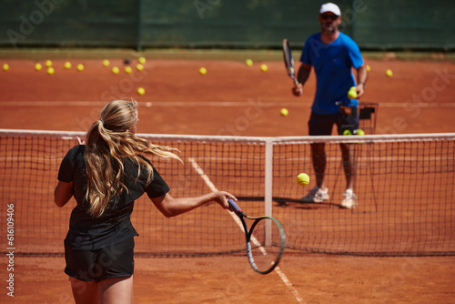 A professional tennis player and her coach training on a sunny day at the tennis court. Training and preparation of a professional tennis player © .shock