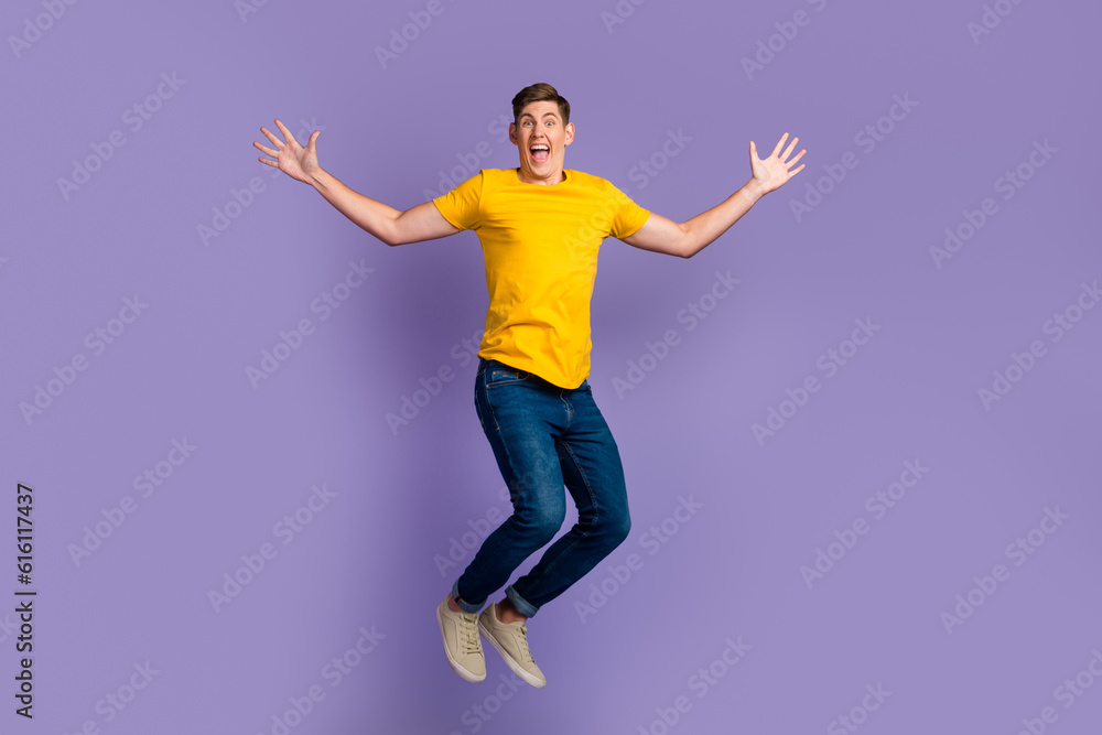 Full body view photo of cheerful guy jumping high up celebrating summer holidays isolated purple color background