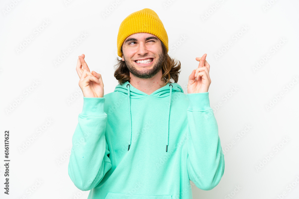 Young handsome man isolated on white chroma background with fingers crossing