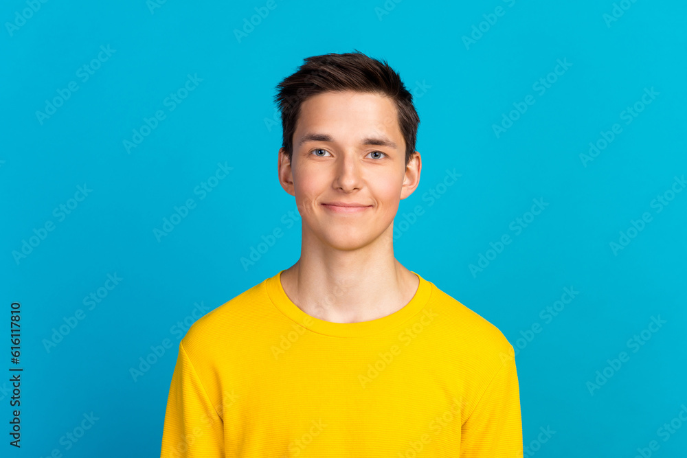 Portrait of nice millennial modern guy in casual outfit looking in camera isolated on blue color background