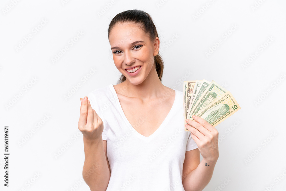 Young caucasian woman taking a lot of money isolated on white background making money gesture Young caucasian woman taking a lot of money isolated on white background making money gesture