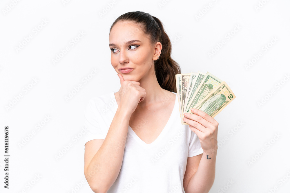 Young caucasian woman taking a lot of money isolated on white background and looking up Young caucasian woman taking a lot of money isolated on white background and looking up