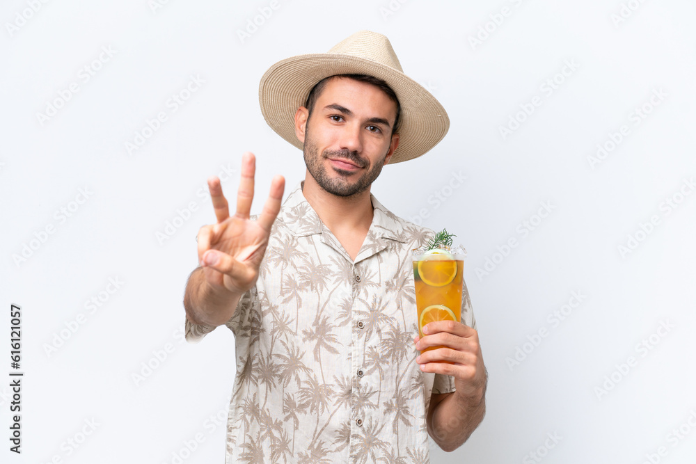 Young caucasian man holding a cocktail isolated on white background happy and counting three with fingers Young caucasian man holding a cocktail isolated on white background happy and counting three with fingers