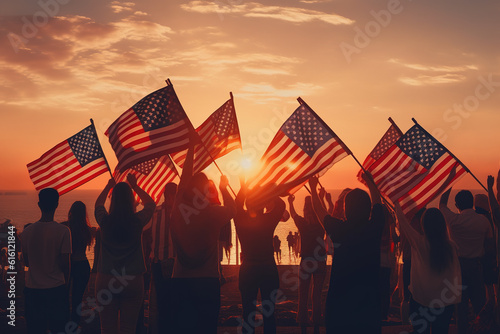 Group of people waving American flags at sunset. 4th July Concept