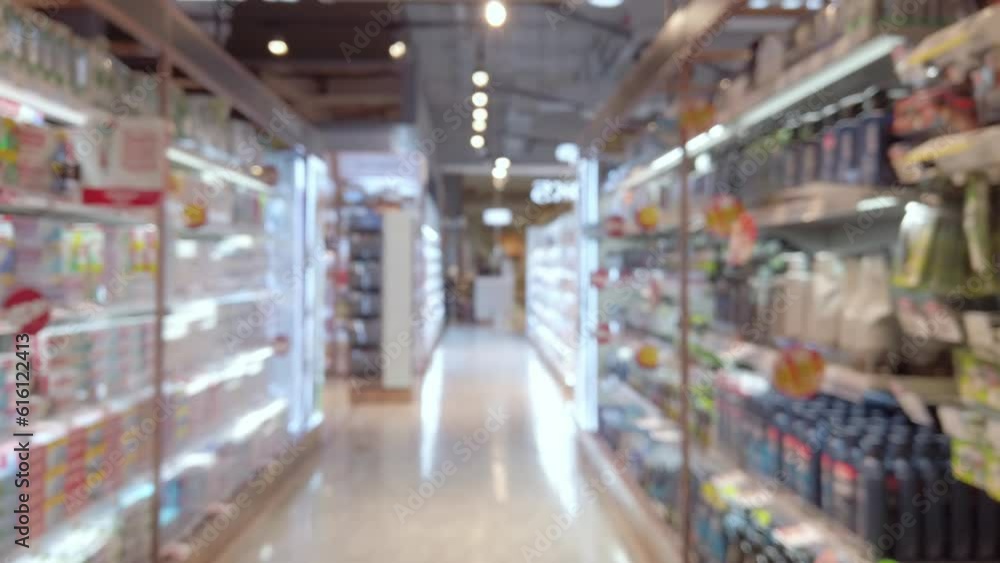 Blurred and trolley moving through product shelf within supermarket Blurred and trolley moving through product shelf within supermarket
