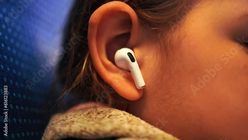 Preschool age child ear close-up with wireless earphone in it
