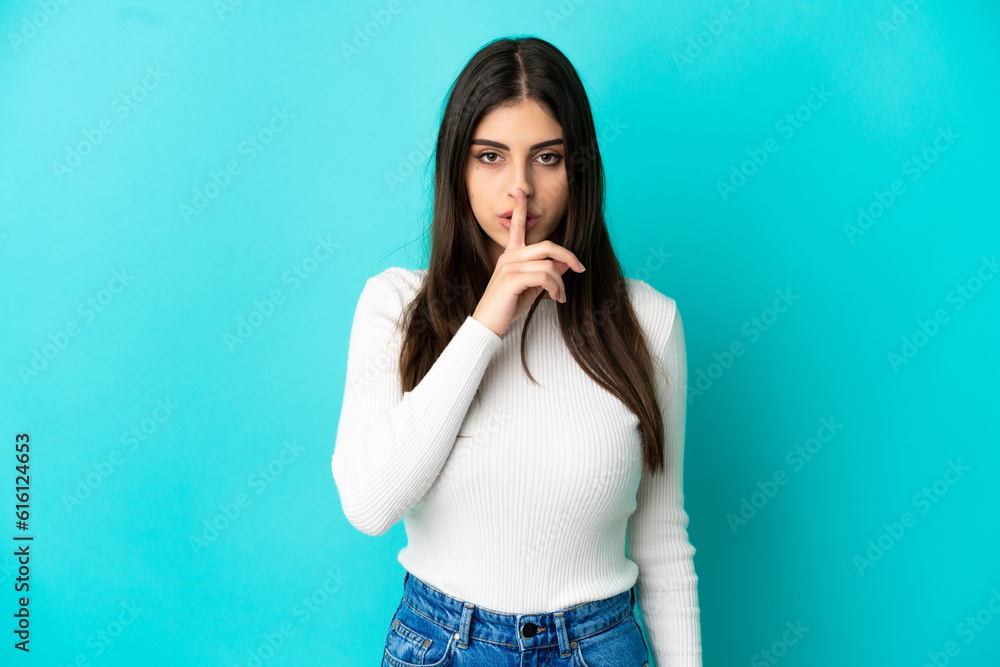 Young caucasian woman isolated on blue background showing a sign of silence gesture putting finger in mouth Young caucasian woman isolated on blue background showing a sign of silence gesture putting finger in mouth