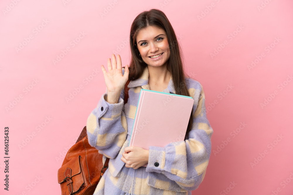 Young student woman isolated on pink background saluting with hand with happy expression Young student woman isolated on pink background saluting with hand with happy expression