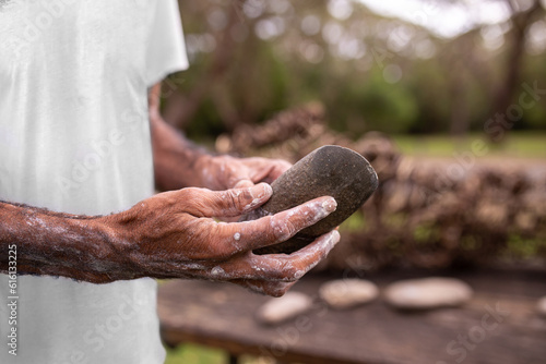 close-up of aboriginal man's hands holding a sacred rock photo