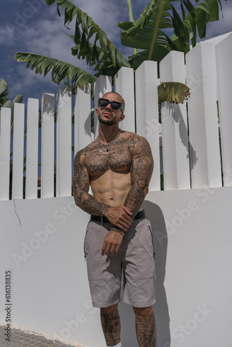Chico guapo tatuado posando en la calle con y sin camiseta en dia soleado en andalucia © MiguelAngelJunquera