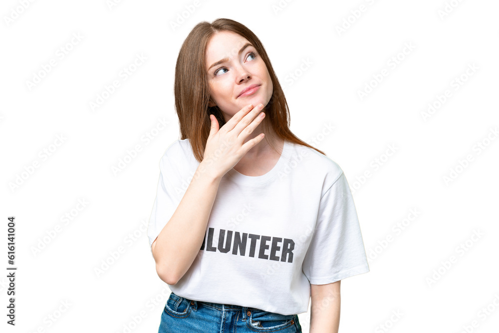 Young volunteer woman over isolated chroma key background looking up while smiling Young volunteer woman over isolated chroma key background looking up while smiling