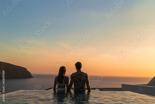 In the background of the sunset at dusk  a couple appreciate the scenery at the pool of high -end hotels