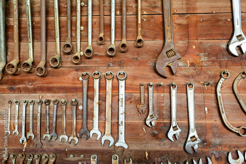 Rust speckled tools hanging neatly in place on farm shed wall photo