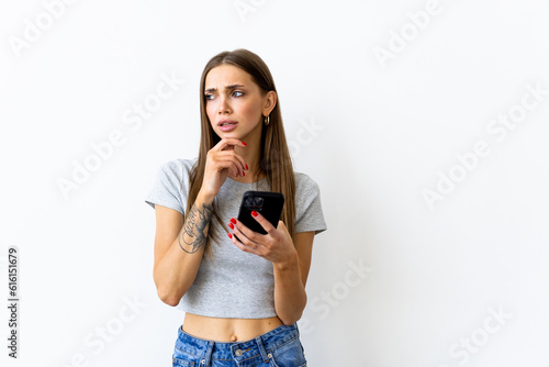 Young woman smiling while using cellphone isolated over white background
