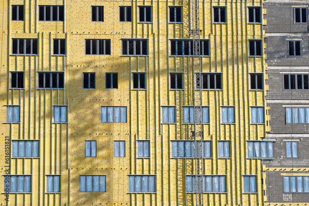 Thermal insulation of external wall with rock wool. Exterior wall heat insulation with mineral wool. Facade insulation of residential building. Warming facade of multi story residential building Thermal insulation of external wall with rock wool. Exterior wall heat insulation with mineral wool. Facade insulation of residential building. Warming facade of multi story residential building