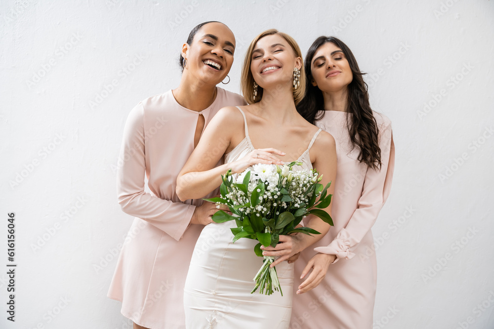 bridal party, special occasion, brunette and interracial bridesmaids hugging blonde bride, friendship goals, grey background, happy multicultural girlfriends, cultural diversity, bridal bouquet bridal party, special occasion, brunette and interracial bridesmaids hugging blonde bride, friendship goals, grey background, happy multicultural girlfriends, cultural diversity, bridal bouquet