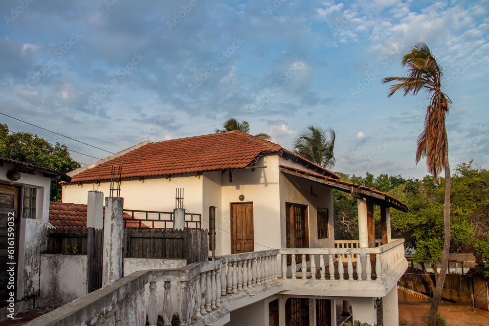Old white house with big balcony connecting two buildings, at the beach of Indian Ocean, constructed in colonial Portuguese style, Pemba city, Mozambique