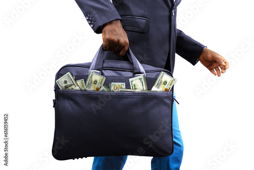 Black African Businessman holding black bag full of stacks of US dollar notes isolated on white background, money coming out of bag. Person carrying bag containing money photo
