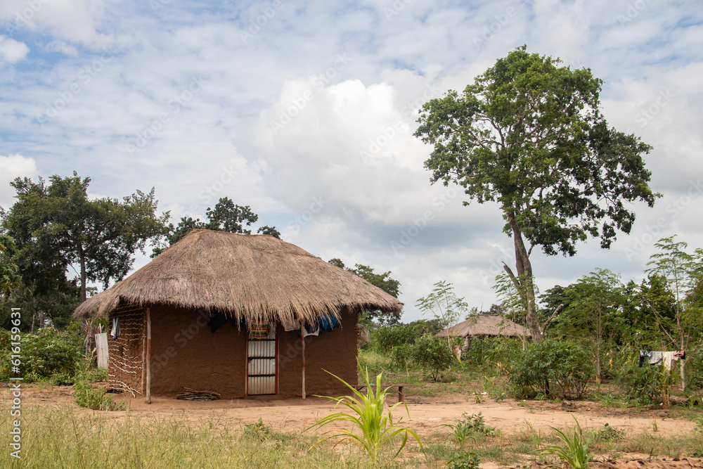 Typical rural mud-house in remote village in Africa with thatched roof, very basic and poor living conditions