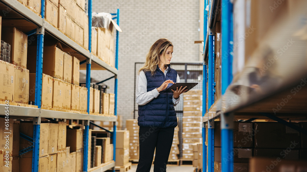 Female logistics worker taking stock using a digital tablet Female logistics worker taking stock using a digital tablet