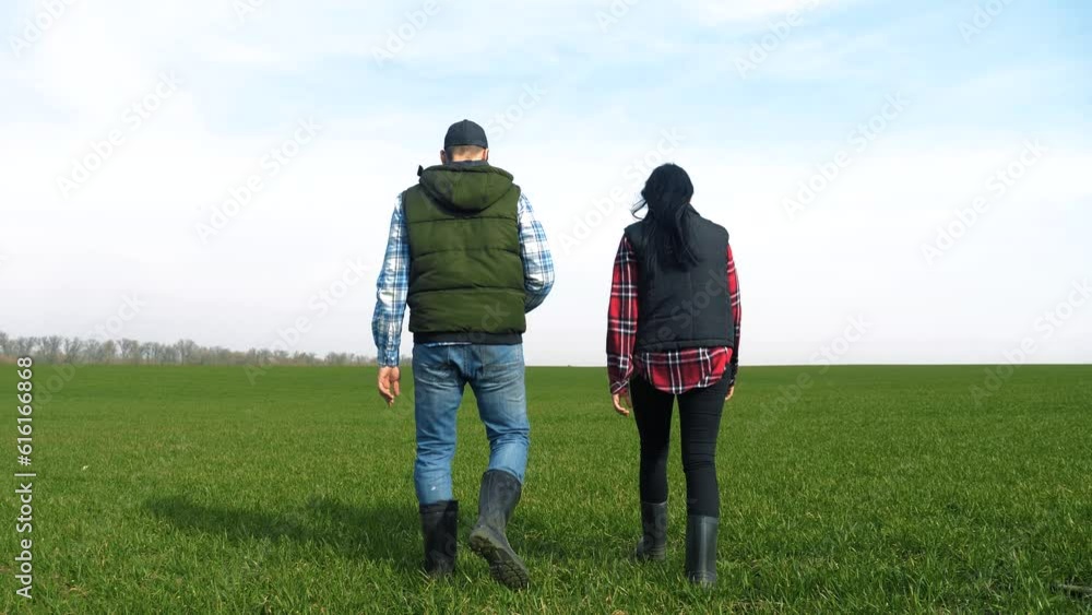 happy family of farmers teamwork a red neck works go on the green field. man and girl farmer are studying eco farming farming harvesting concept. woman and lifestyle worker go walking on agricultural happy family of farmers teamwork a red neck works go on the green field. man and girl farmer are studying eco farming farming harvesting concept. woman and lifestyle worker go walking on agricultural