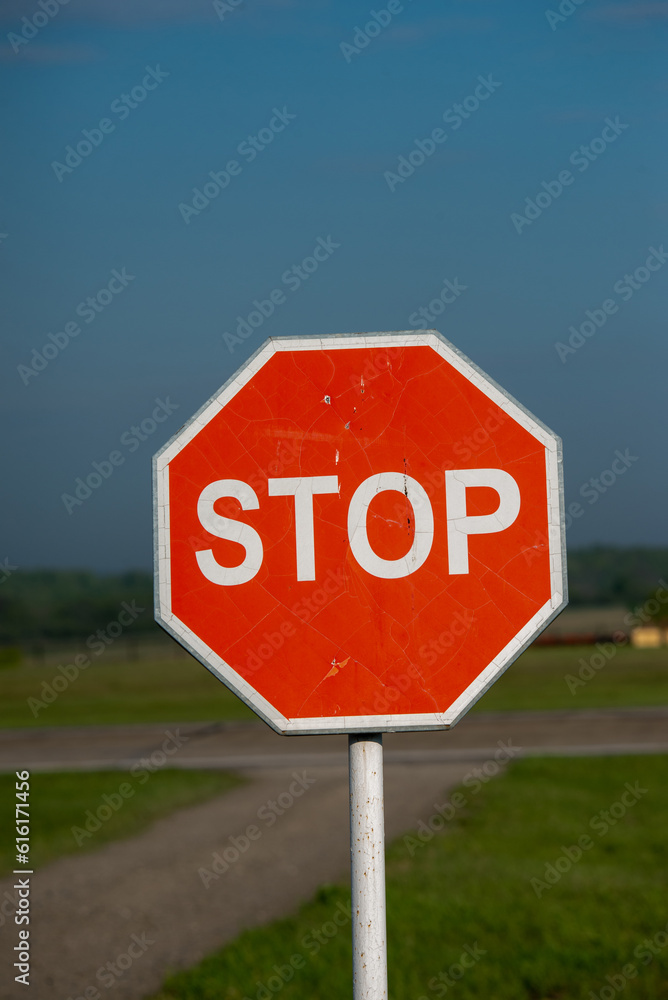 Stop sign on a rural road. Selective focus with shallow depth of field.