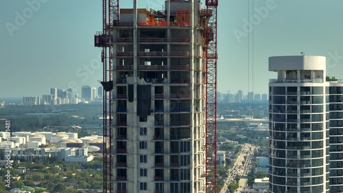 New construction site of developing residense in american urban area. Industrial tower lifting cranes in Miami, Florida. Concept of housing growth in the USA photo