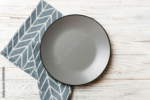 Top view on colored background empty round gray plate on tablecloth for food. Empty dish on napkin with space for your design