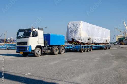 Unloading operation of project  cargo with port heavy lift cranes A crane on a large cargo ship docks loading a diesel-electric locomotive.  at Laem Chabang Port photo