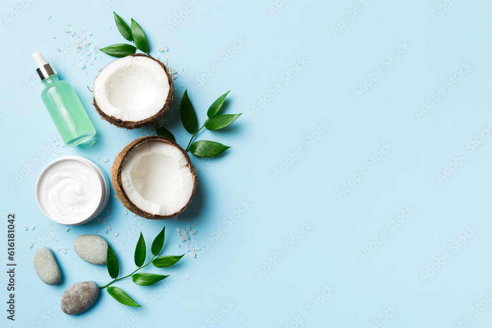 Coconut with jars of coconut oil and cosmetic cream on colored background. Top view. Free space for your text. Natural spa coconut cosmetics and organic treatment concept Coconut Spa composition Coconut with jars of coconut oil and cosmetic cream on colored background. Top view. Free space for your text. Natural spa coconut cosmetics and organic treatment concept Coconut Spa composition