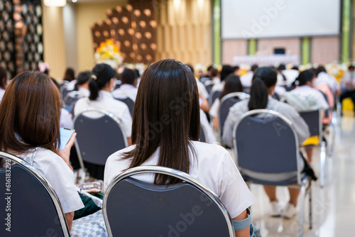 Rear view of college students listening to the lecture in the hall