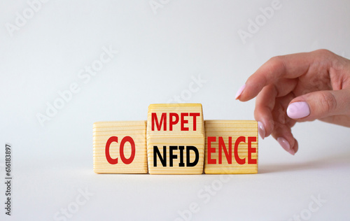 Competence and Confidence symbol. Businessman hand points at wooden cubes with words Confidence and Competence. Beautiful white background. Business concept. Copy space