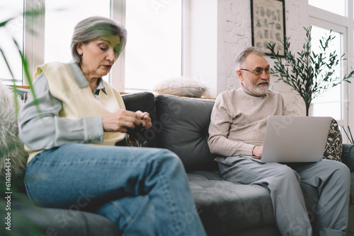 Aged couple resting on couch at home