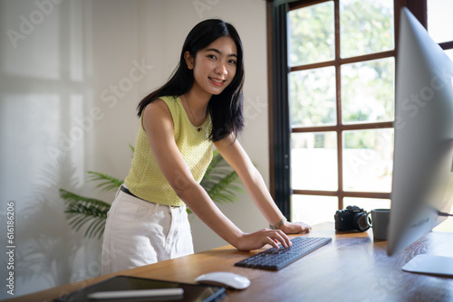 Happy young Asian Woman working on computer Business Data Analyst.