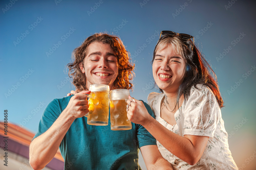 Interracial friends toasting draft beer against the sunset. Interracial friends toasting draft beer against the sunset.