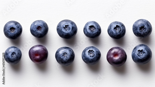 Two rows of ripe blueberries on the white paper background, minimal concept for design