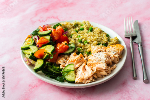 Healthy lunches, quinoa with green peas, with baked red fish salmon and fresh salad of tomato, cucumber and greens