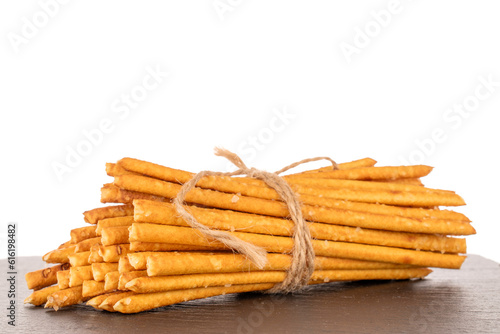 Straw is a bakery product. Several straws tied with jute string on slate stone isolated on white background