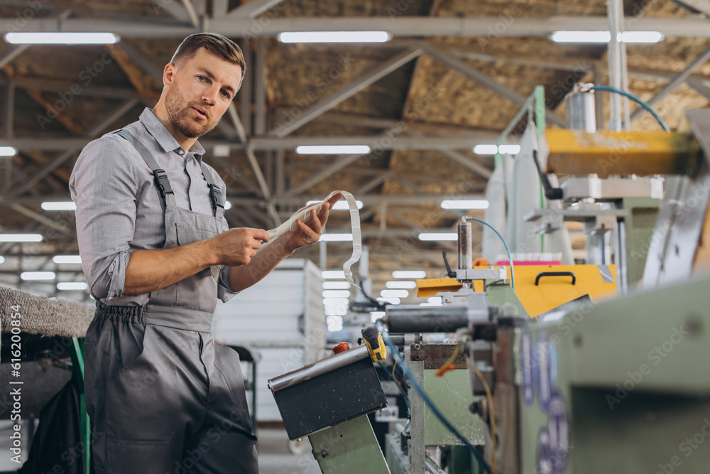 Factory male bearded worker is programming a CNC milling machine with copy space. Factory male bearded worker is programming a CNC milling machine with copy space.