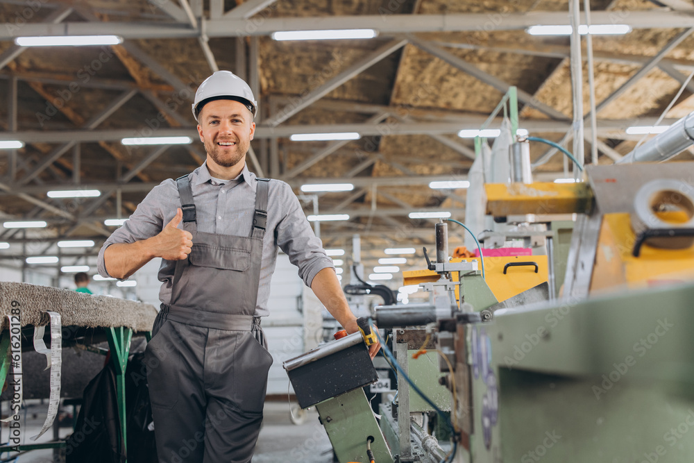 Factory male bearded worker is programming a CNC milling machine with copy space. Factory male bearded worker is programming a CNC milling machine with copy space.
