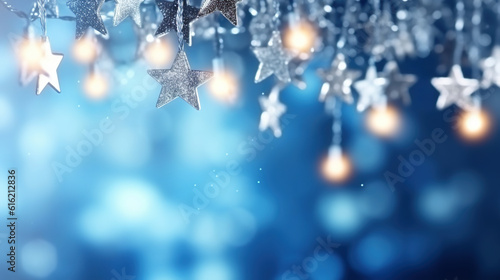 Christmas blue background with garland of Christmas stars and bokeh lights.