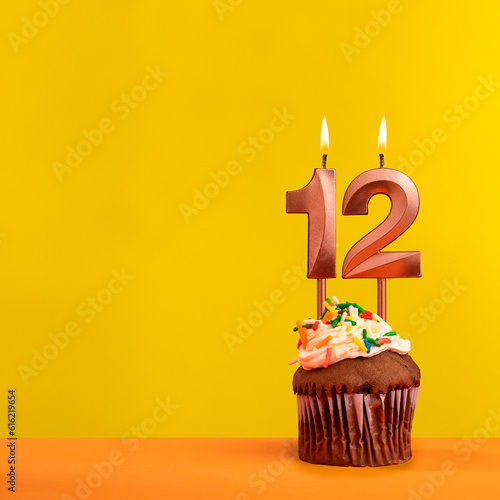 Candle with flame number 12 - Birthday card on yellow background