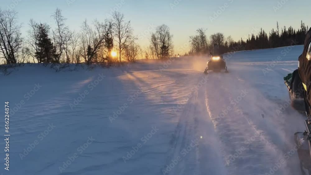 View from the snowmobile at speed. Large snowy field in winter. Evening sunset in Siberia. Red sun at sunset View from the snowmobile at speed. Large snowy field in winter. Evening sunset in Siberia. Red sun at sunset