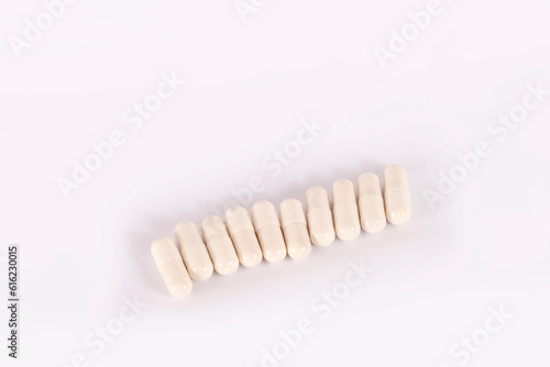 White pills in capsules on a white background. Medical capsule pills  top view. Packaging for tablets  capsules or supplements. The concept of medicine and health. Vitamins for health and sports