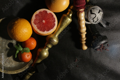 bowl with tobacco for hookah. nargile smoking. berries and fruits on a black background.