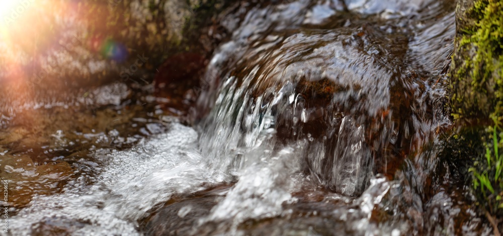 Fresh Water running down the River Stream around the smooth rocks.