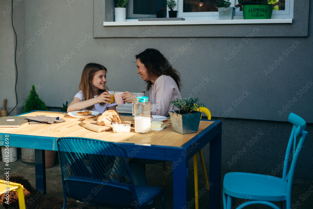 Mother and daughter clinking glasses during breakfast. Mother and daughter clinking glasses during breakfast.