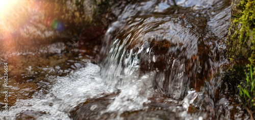 Fresh Water running down the River Stream around the smooth rocks.